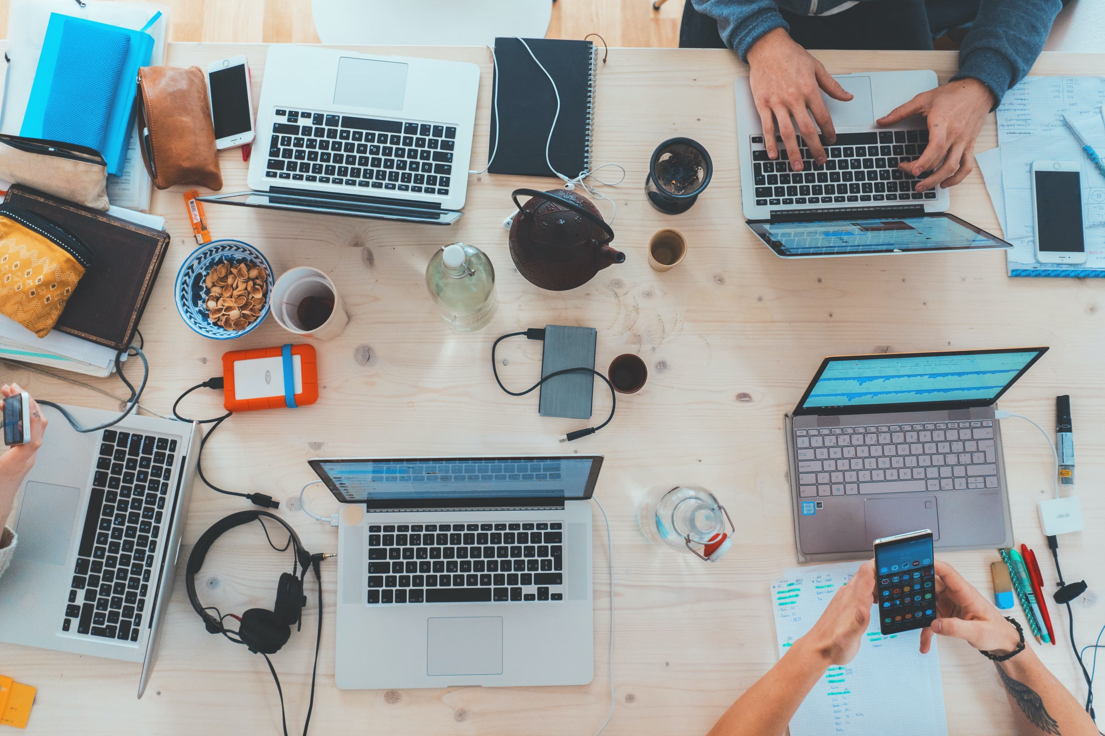 Desk with people working on laptops