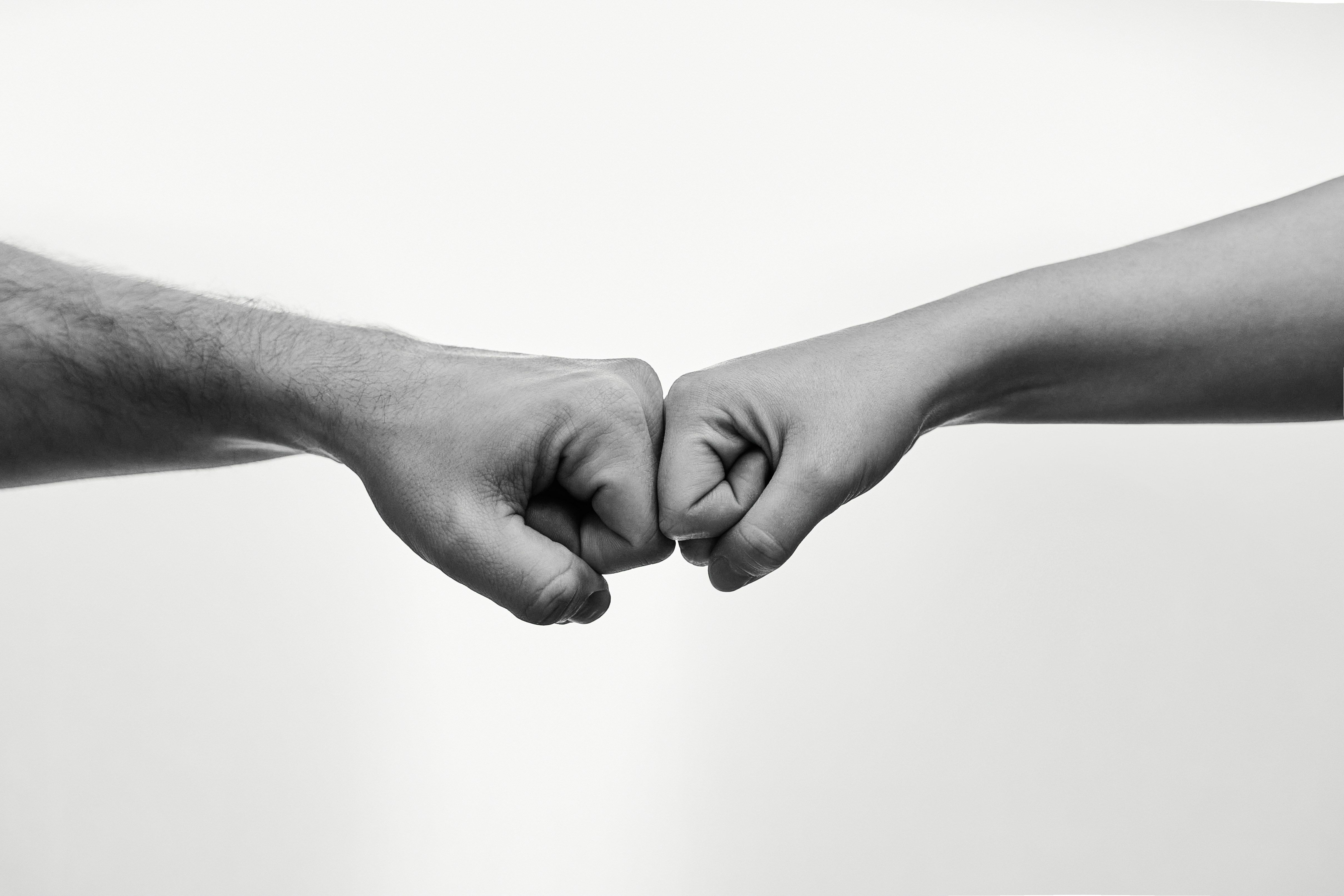 two people fist bumping